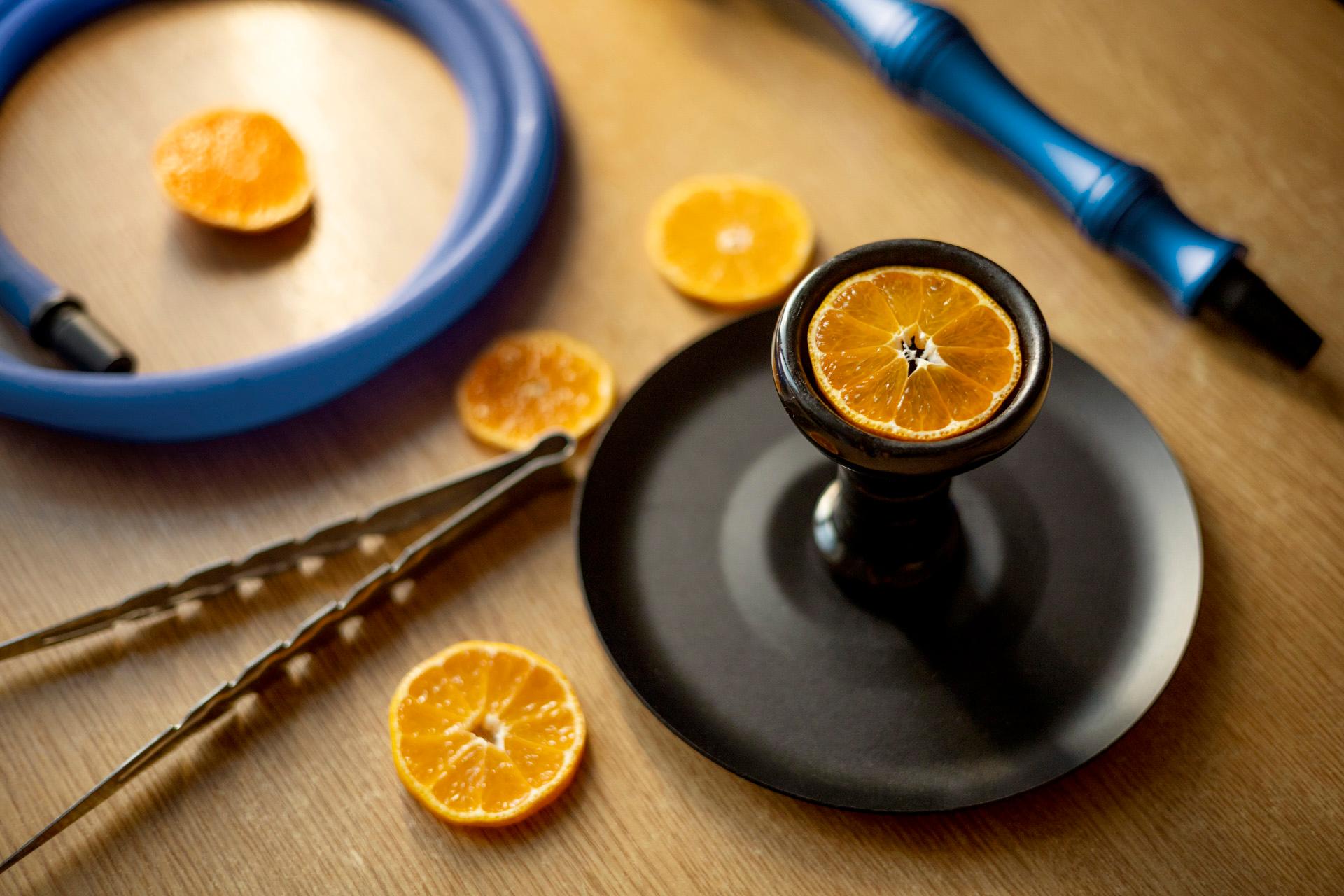 Hookah and orange slices standing on a wooden table