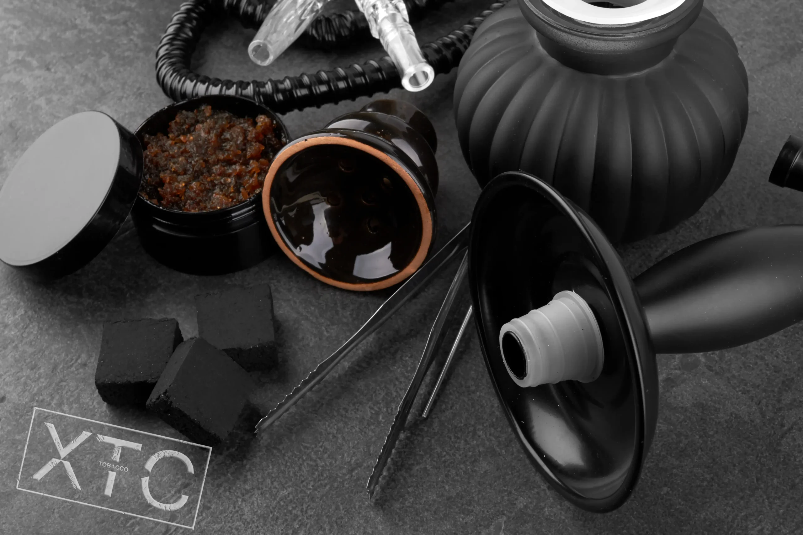 tobacco, hookah, coal and hookah bowl setup on dark background. XTC tobacco hookah setup