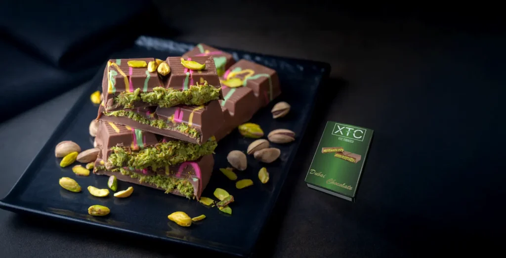 xtc tobacco's dubai chocolate flavor, next to hand made dubai chocolate and pistachio beans